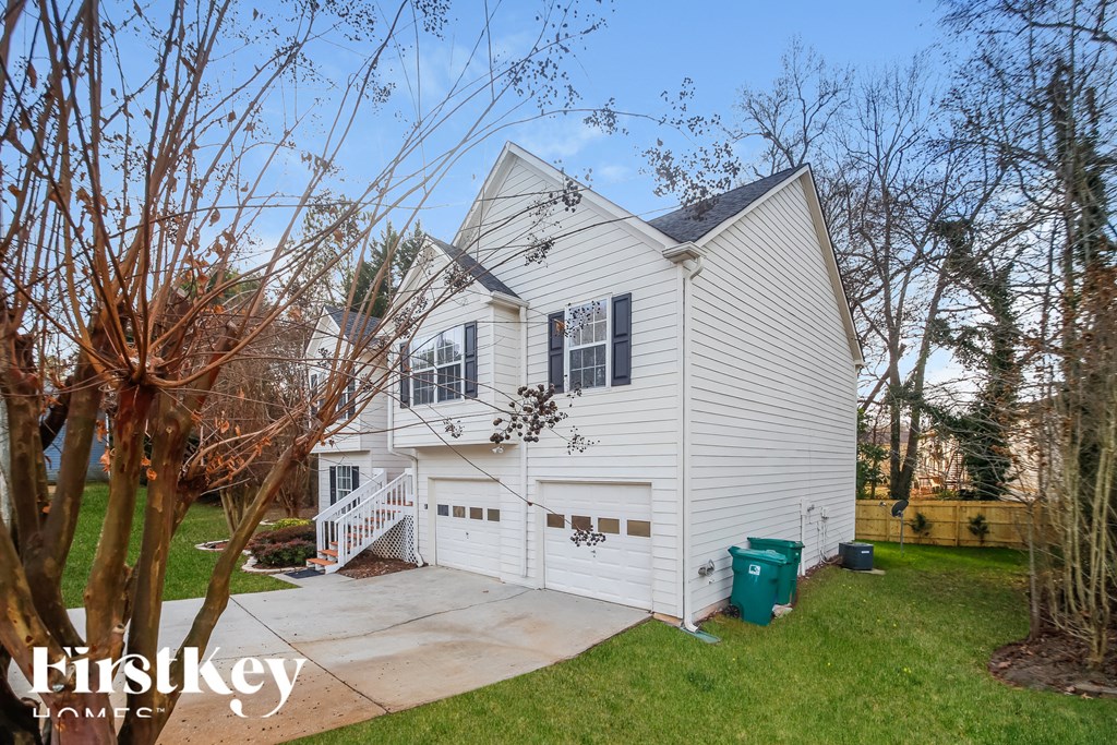 the front of a white house with a driveway