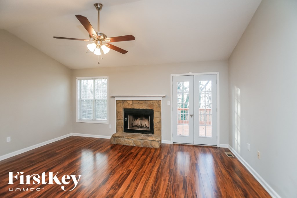 a living room with a fireplace and a ceiling fan