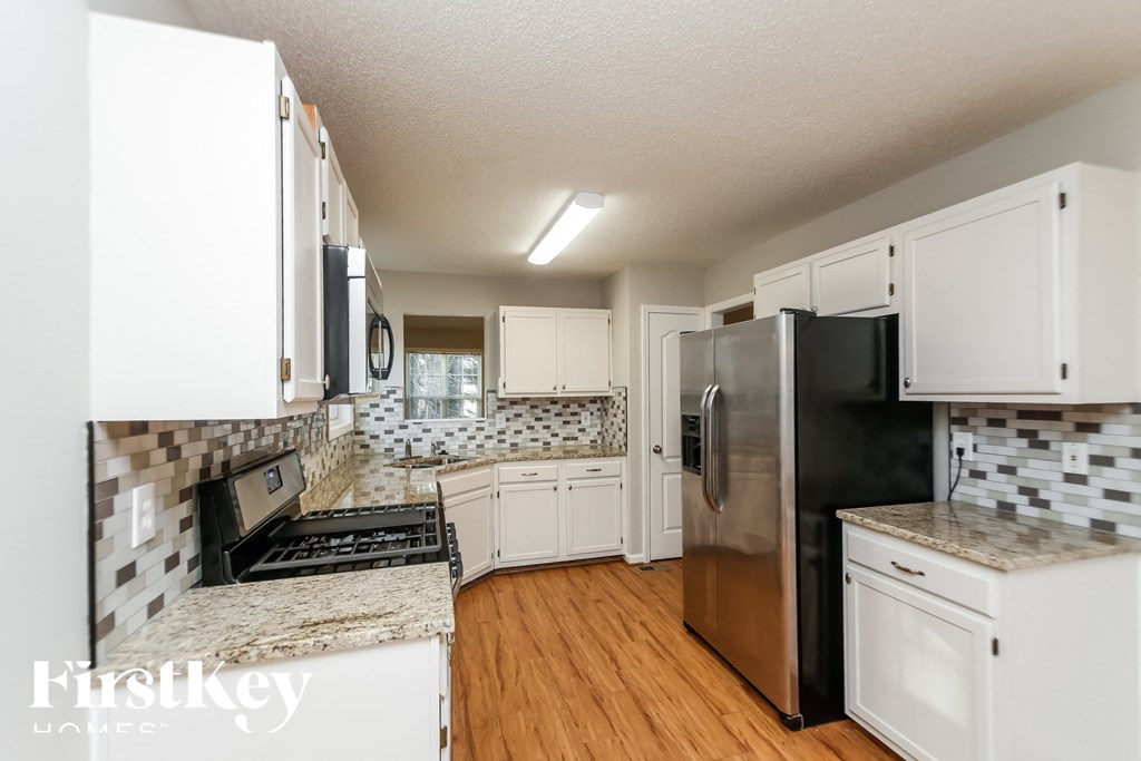 a kitchen with white cabinets and a stainless steel refrigerator