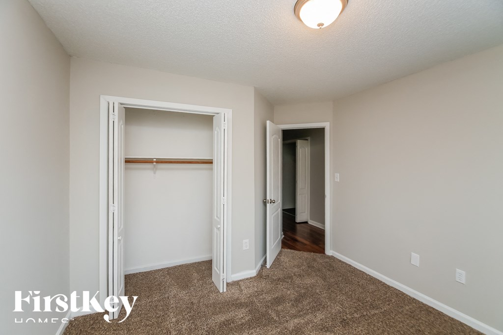 a bedroom with a closet and a door to a hallway