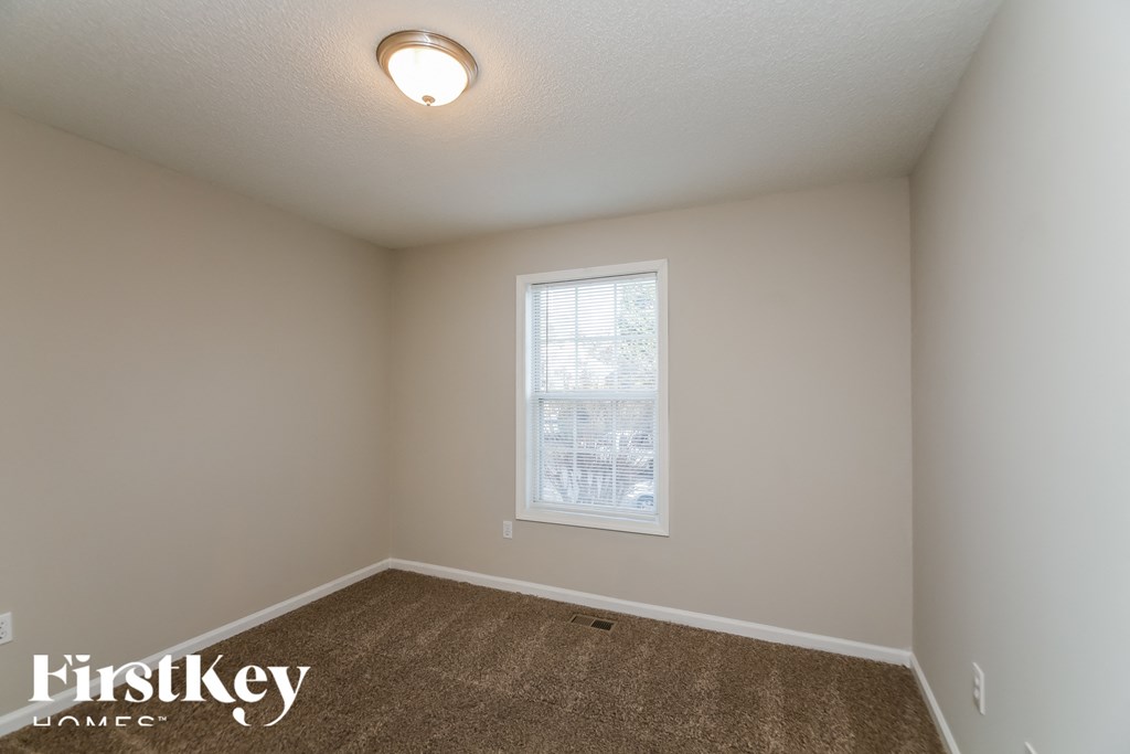 a bedroom with a carpeted floor and a window