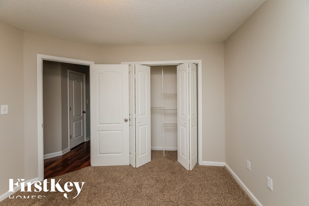 a bedroom with two closets and a carpeted floor