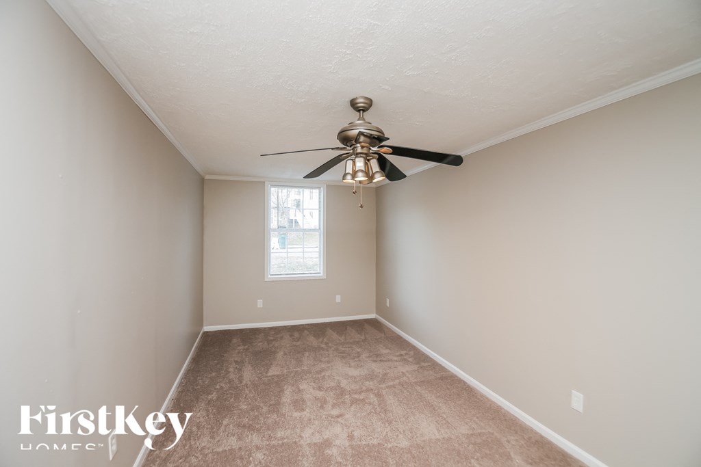 a empty room with a ceiling fan and a window