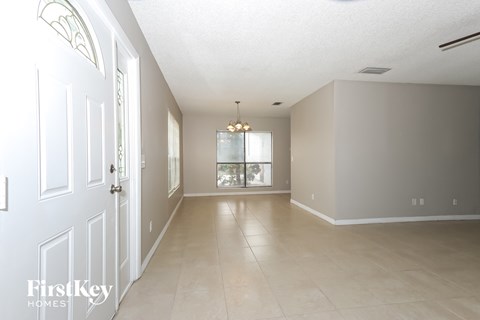 A spacious room with a door on the left and a window on the right.