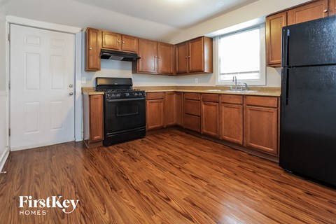 a kitchen with wood flooring and black appliances