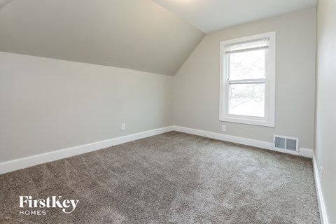 a bedroom with a carpeted floor and a window