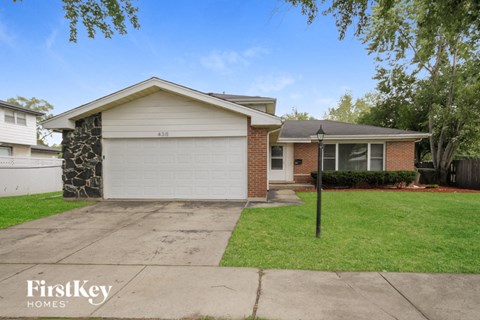 a home with a white garage door and a lawn