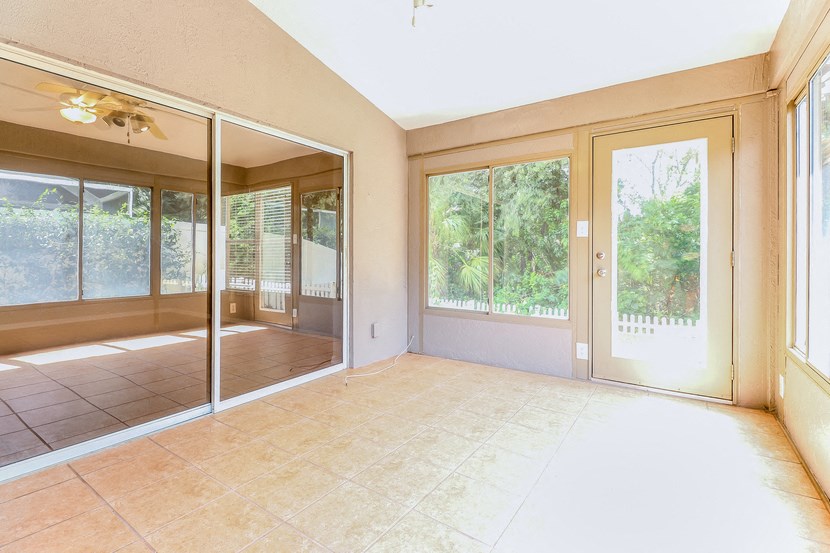 an empty living room with sliding glass doors to a patio