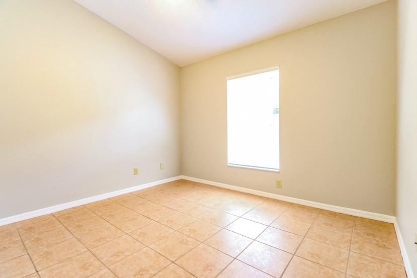 an empty room with tiled floors and a window