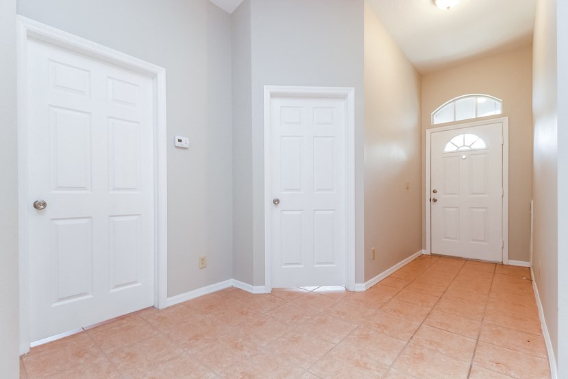 an empty room with two doors and a tiled floor