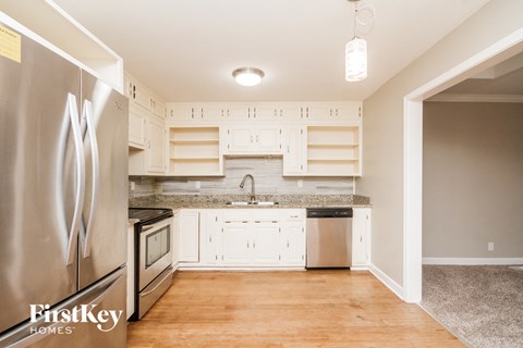 a kitchen with white cabinets and stainless steel appliances