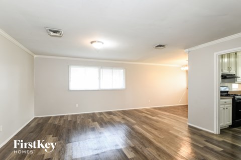 A room with wooden floors and a window is available for rent.