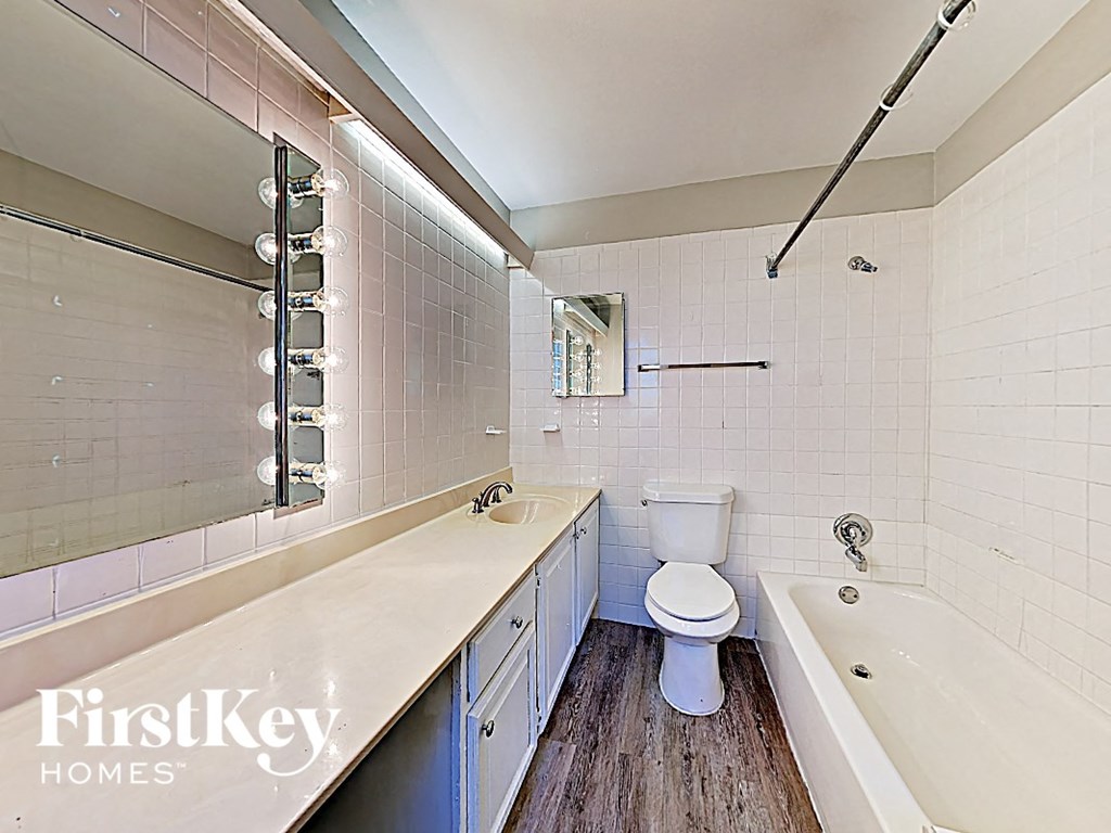 a white bathroom with a toilet and a tub and a sink