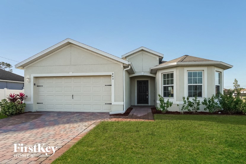 a white house with a lawn and a garage door