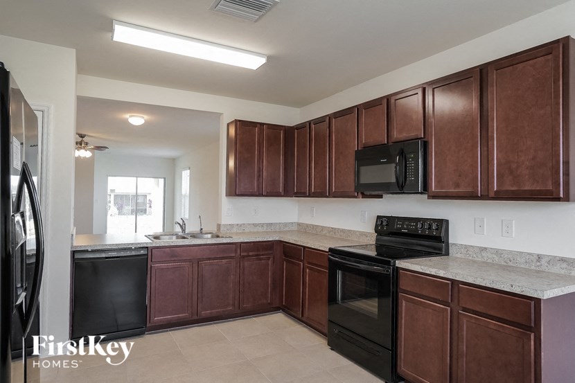 a kitchen with dark wood cabinets and black appliances