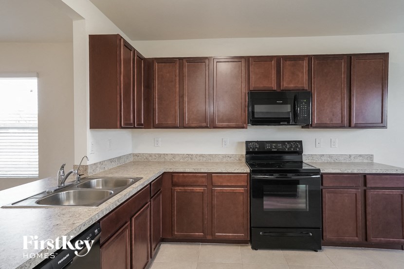 a kitchen with wooden cabinets and black appliances and a sink