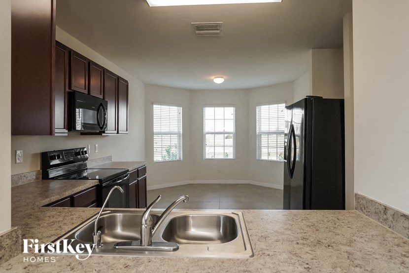a kitchen with a sink and a refrigerator and a window