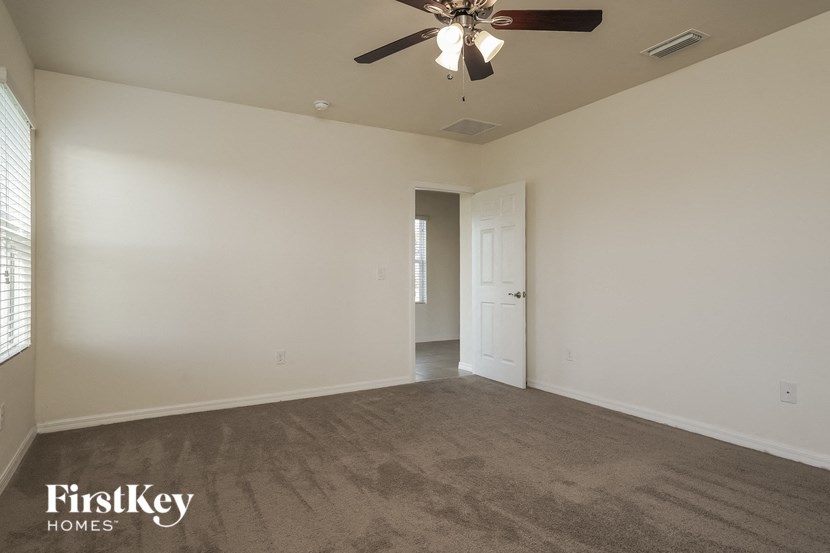 the living room of an empty house with a ceiling fan