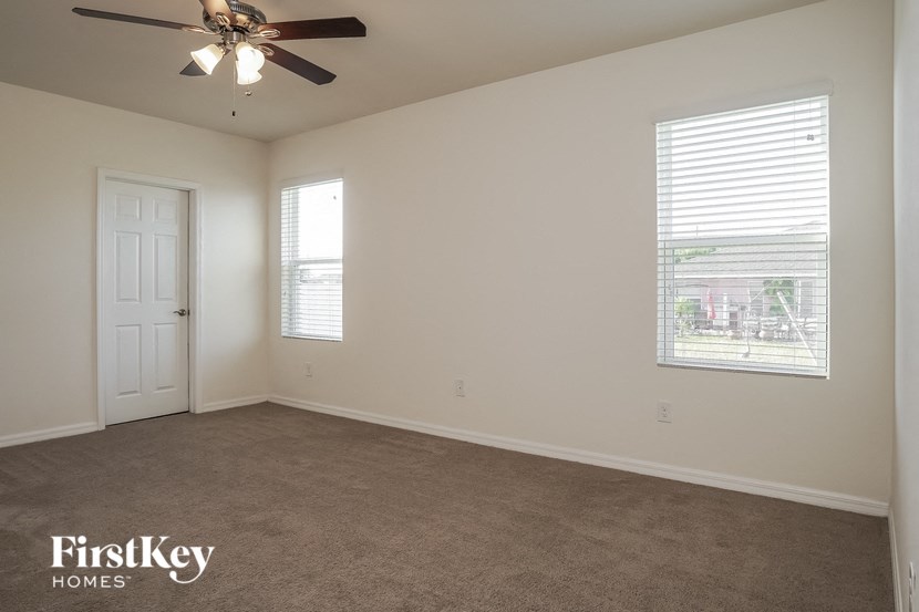 a bedroom with a ceiling fan and a window