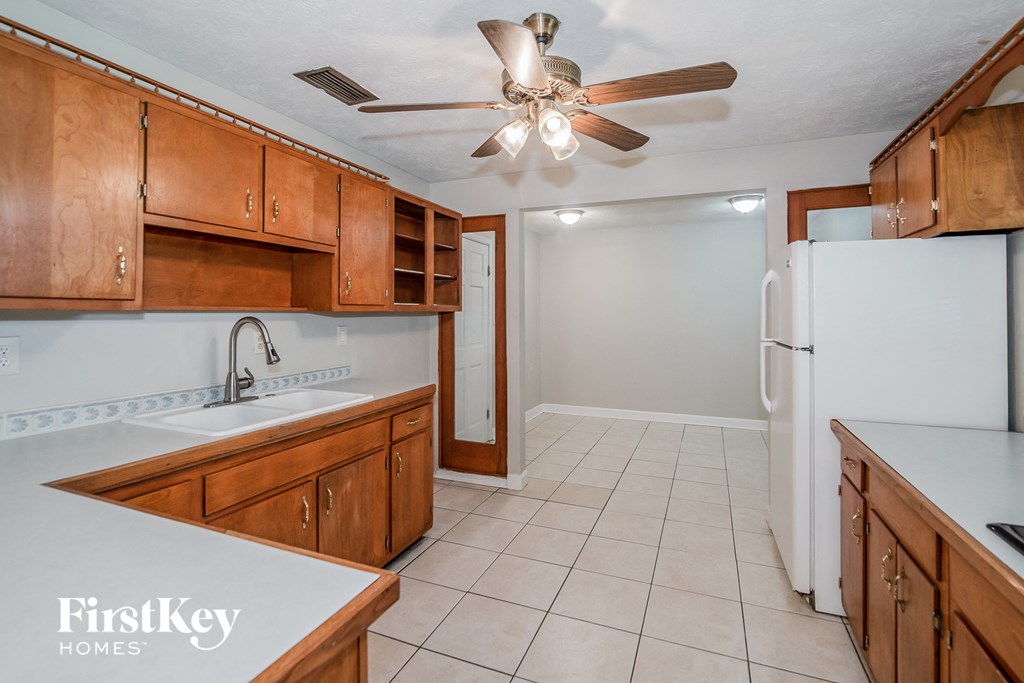 a kitchen with wooden cabinets and a sink and a refrigerator