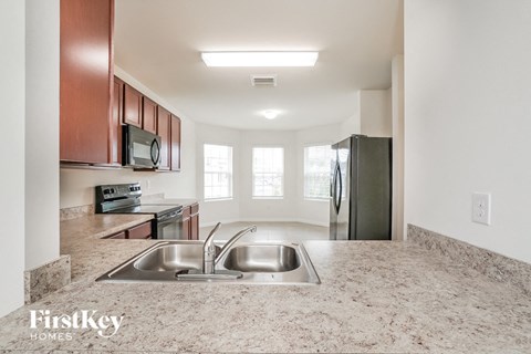 A kitchen with a sink and a refrigerator.