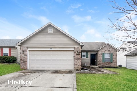 a white garage door in front of a brick house