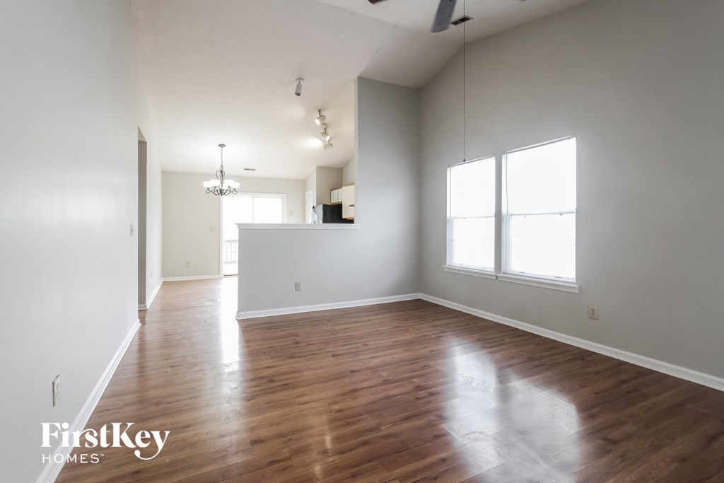 an empty living room with white walls and wood floors