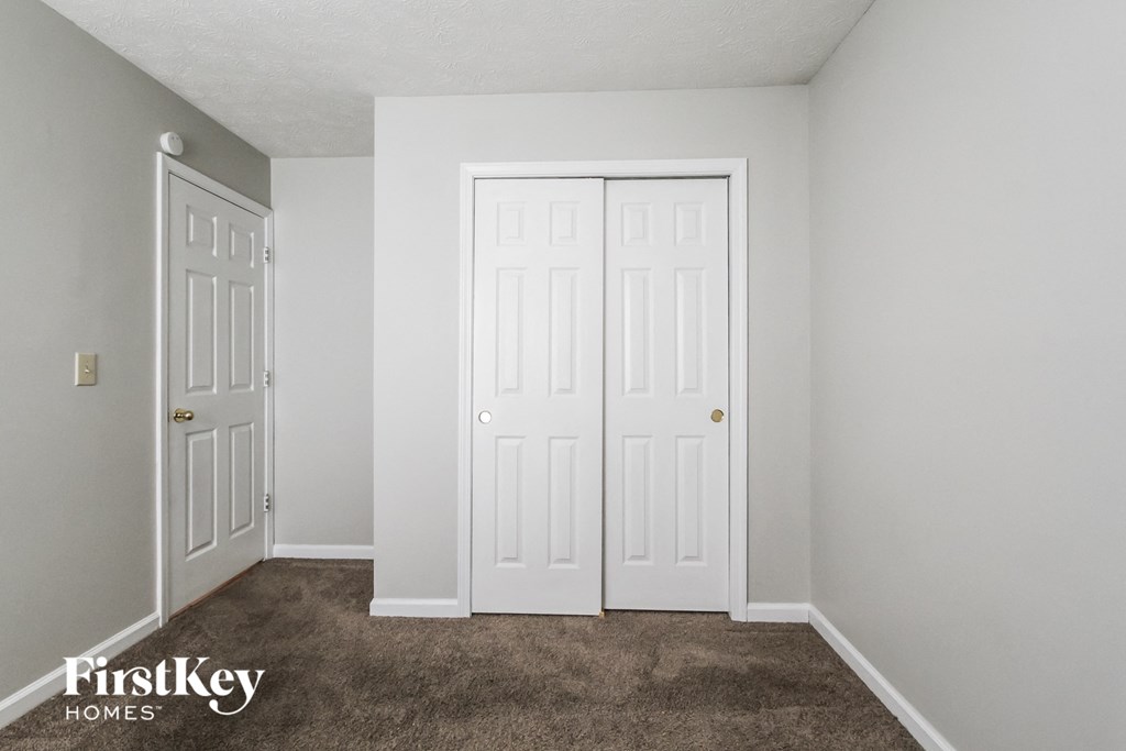 a bedroom with two closets and a carpeted floor
