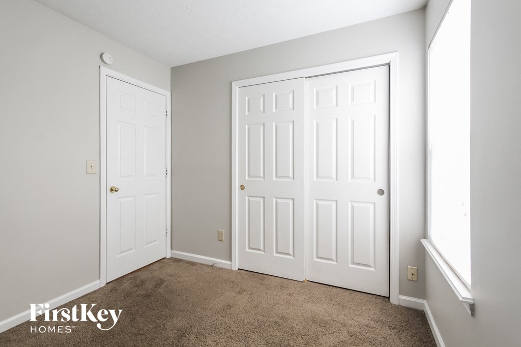 a bedroom with two white doors and a carpeted floor