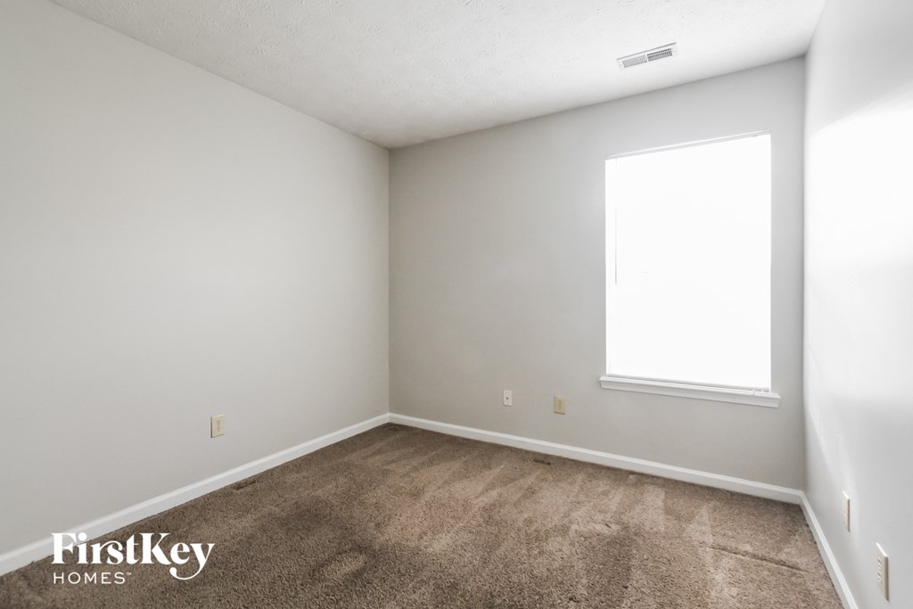 an empty room with carpet and a window
