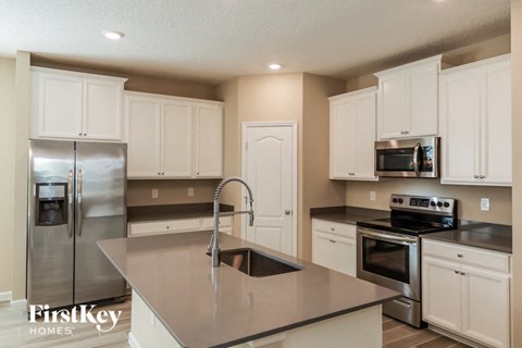 A kitchen with a stainless steel refrigerator and a stainless steel oven.