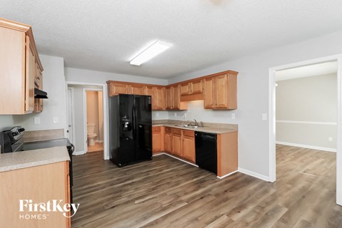 A kitchen with wooden cabinets and black appliances.