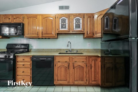 A kitchen with wooden cabinets and a stainless steel refrigerator.
