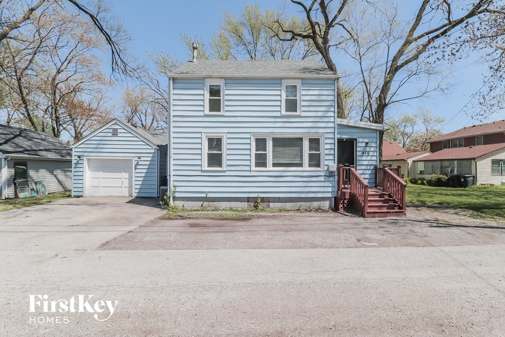 A blue house with a porch and a garage door.