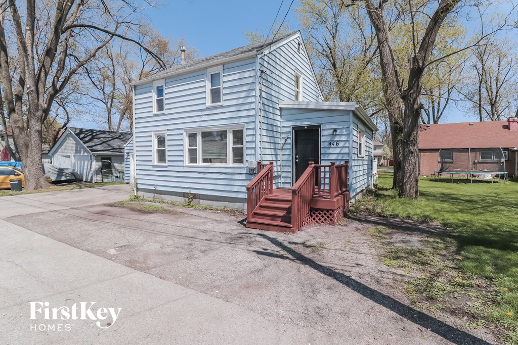 A blue house with a red front porch is for sale.