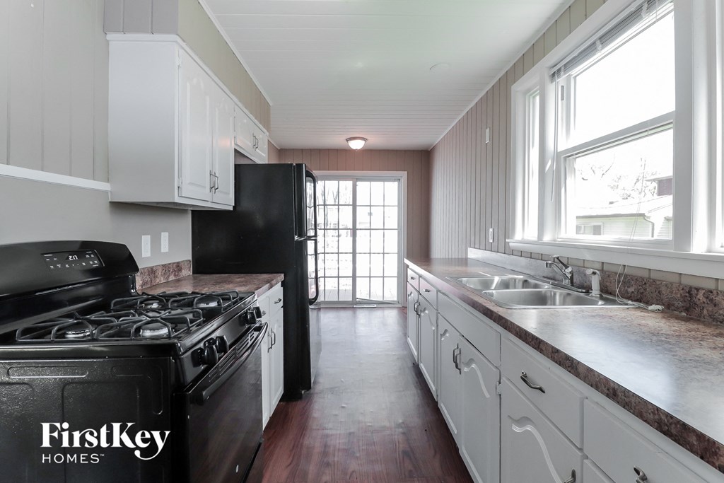 A kitchen with a black stove top oven and a black refrigerator.