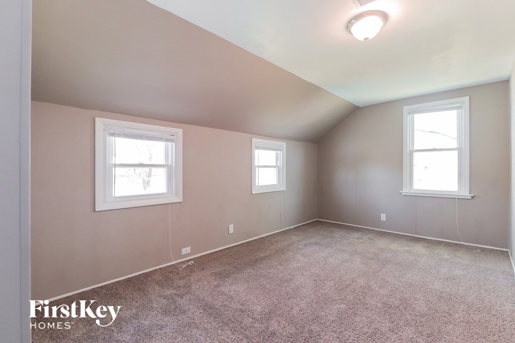 A room with two windows and a carpeted floor.