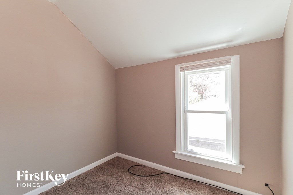 A room with a window and a carpet on the floor.
