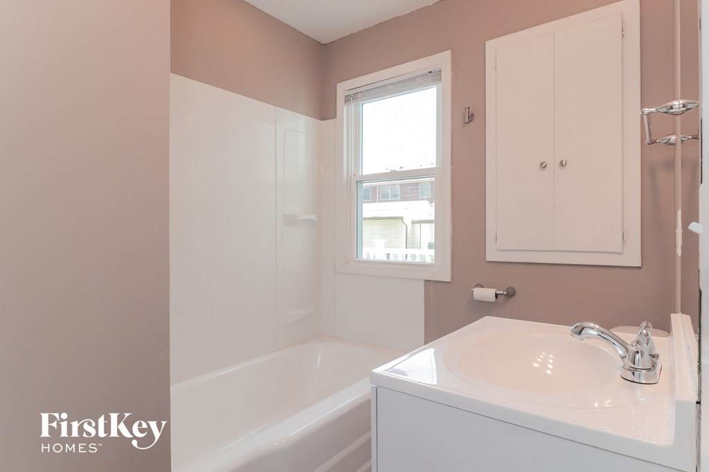 A white sink is on a counter in a bathroom.