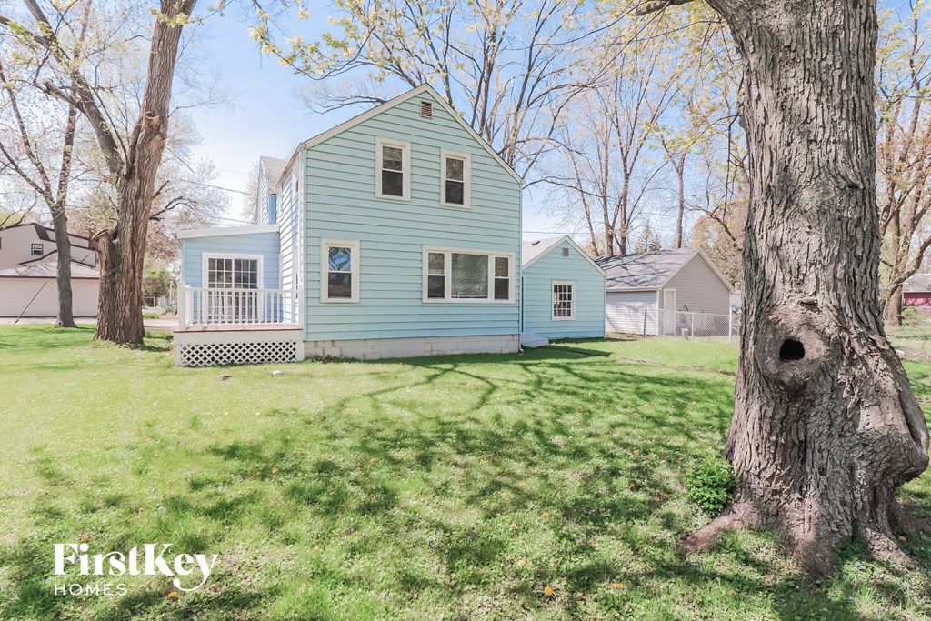 A blue house with a tree in front of it.