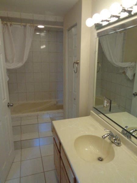 a white bathroom with a sink and a mirror