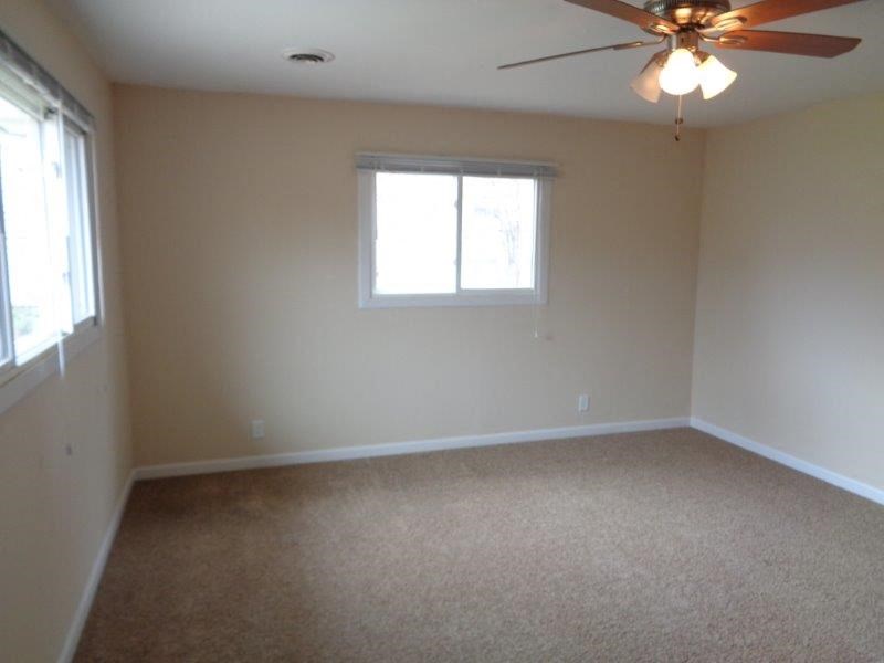 a living room with a ceiling fan and a window