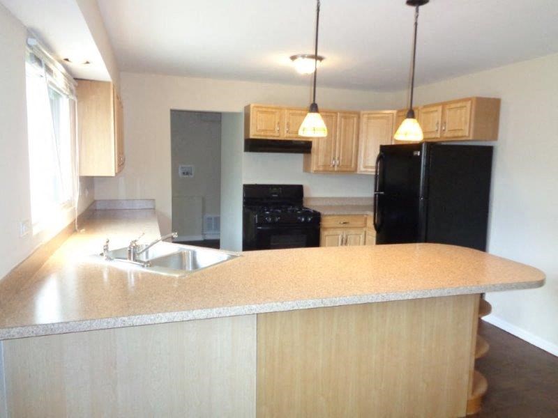 a kitchen with a sink and a black refrigerator