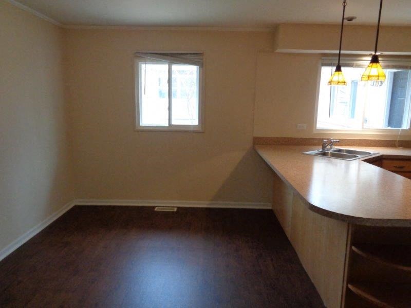 an empty kitchen with a counter top and a sink