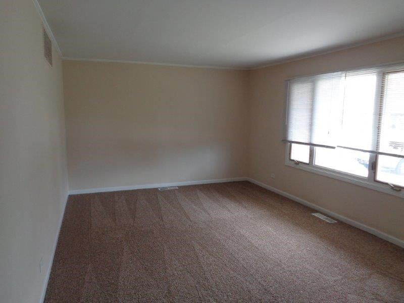 an empty room with a window and a wooden floor