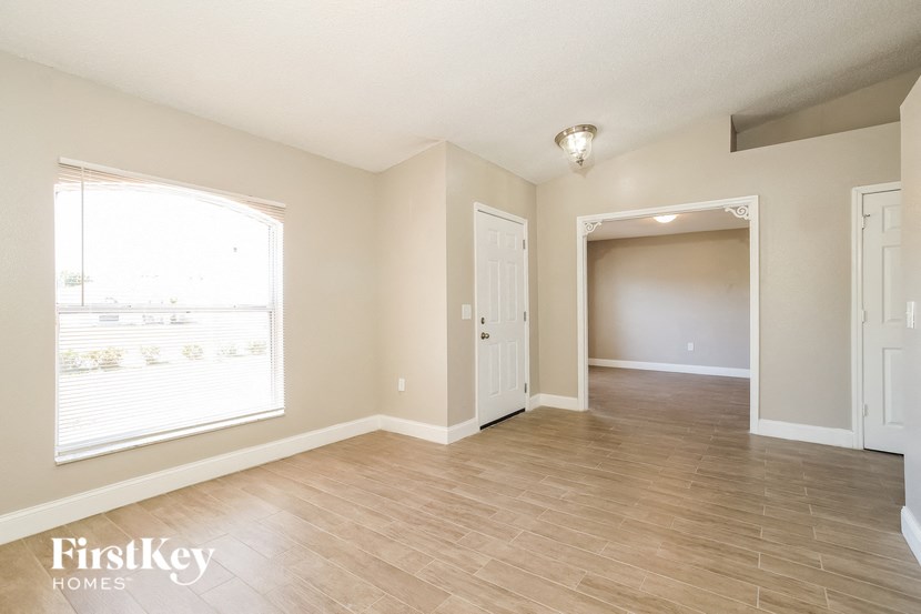 an empty living room and dining room with a large window