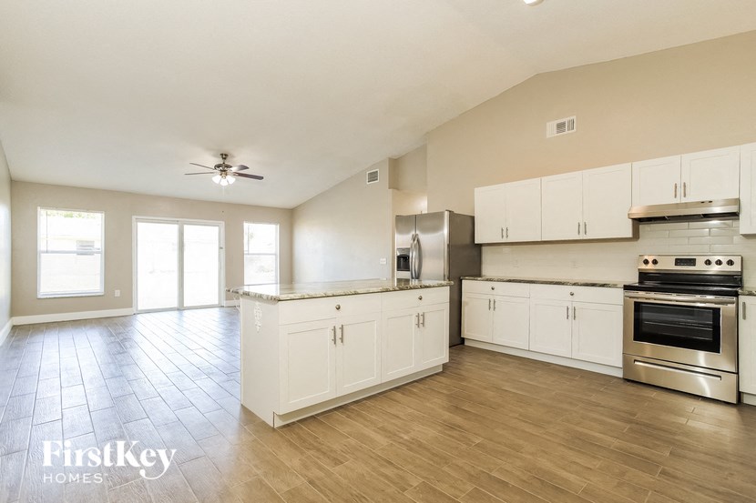 an empty kitchen with white cabinets and stainless steel appliances