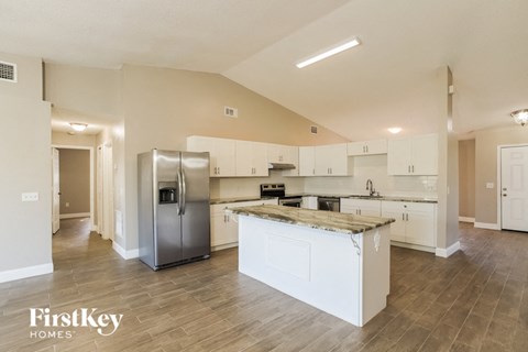 a large kitchen with stainless steel appliances and white cabinets