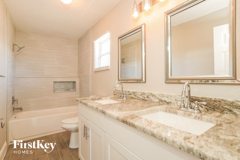 a bathroom with two sinks and a toilet and a mirror