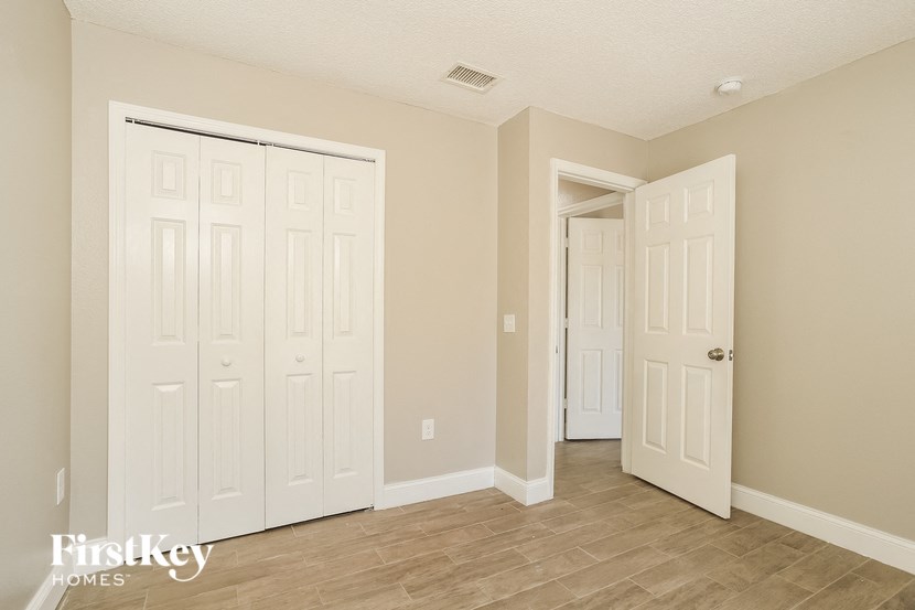 a bedroom with two doors and a door to a closet